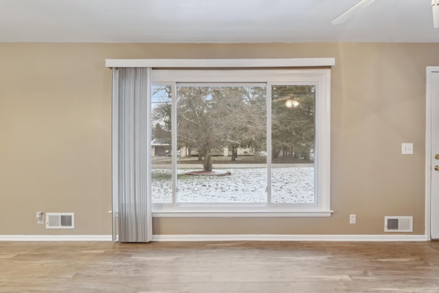 empty room with ceiling fan and light hardwood / wood-style floors