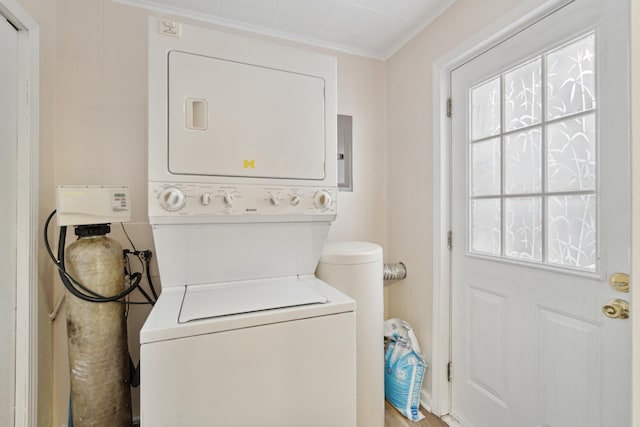 laundry area featuring stacked washer / dryer and ornamental molding