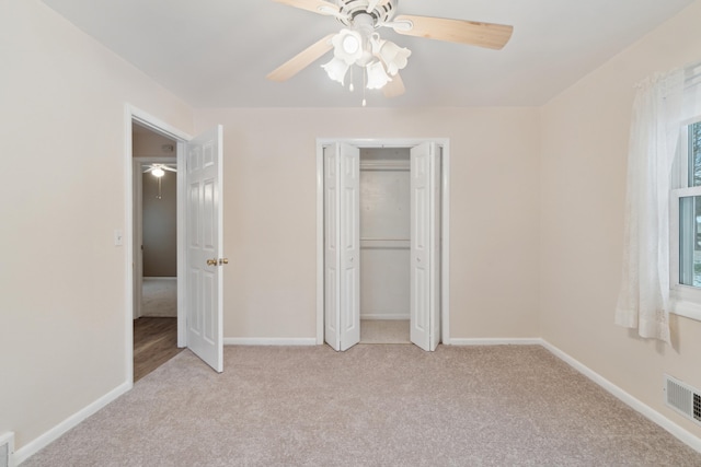 unfurnished bedroom with light carpet, a closet, and ceiling fan