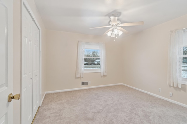 unfurnished bedroom featuring ceiling fan, a closet, and light colored carpet