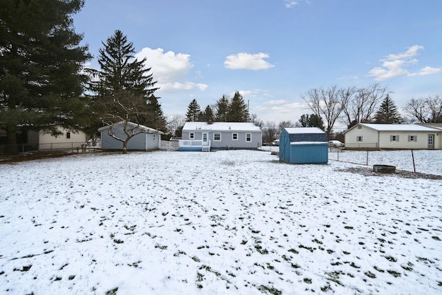 snowy yard featuring a storage unit