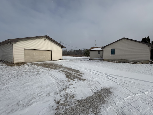 view of snow covered exterior featuring a garage