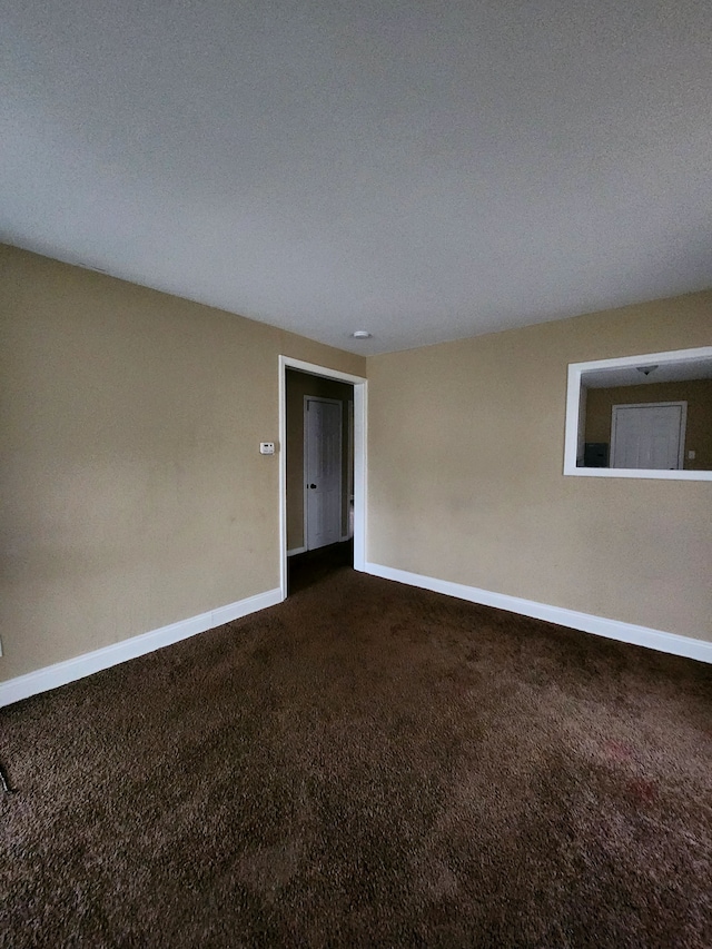 carpeted empty room with a textured ceiling