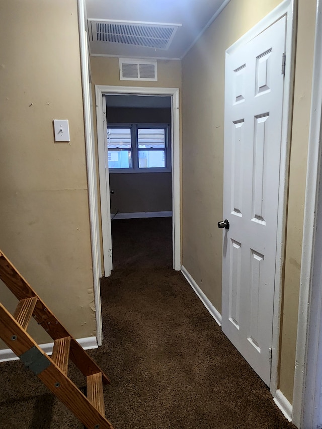 hall with dark colored carpet