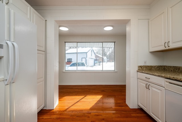 kitchen featuring white appliances, stone counters, crown molding, white cabinetry, and dark hardwood / wood-style flooring