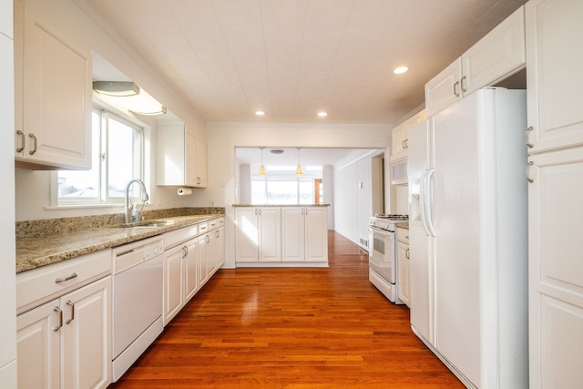 kitchen featuring white appliances, white cabinets, light hardwood / wood-style floors, sink, and plenty of natural light