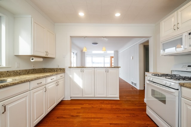 kitchen with white appliances, white cabinets, hanging light fixtures, kitchen peninsula, and hardwood / wood-style flooring