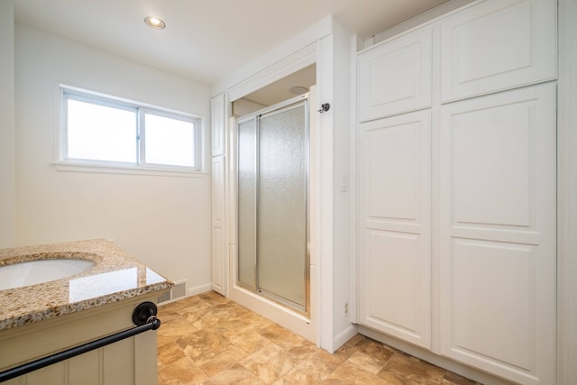 bathroom featuring walk in shower and vanity