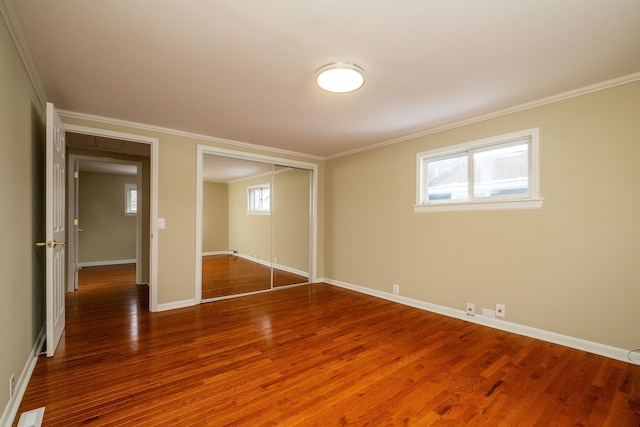 unfurnished bedroom featuring hardwood / wood-style floors, a closet, and ornamental molding