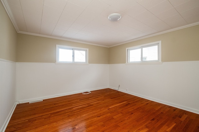 unfurnished room with wood-type flooring, plenty of natural light, and ornamental molding