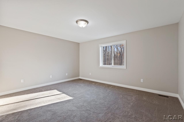 unfurnished room featuring dark carpet