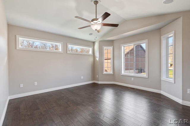 empty room with dark hardwood / wood-style flooring, vaulted ceiling, and ceiling fan