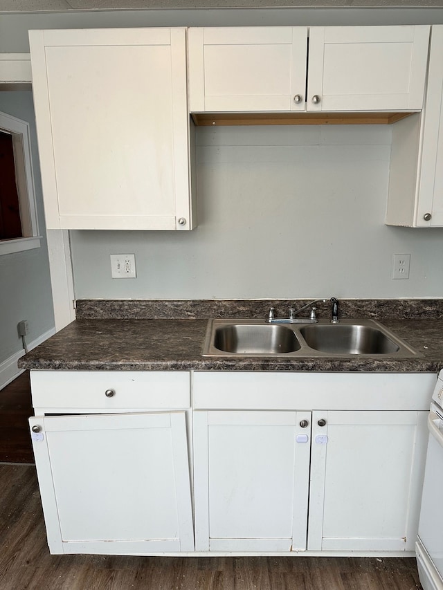 kitchen with white cabinetry, sink, and dark hardwood / wood-style floors