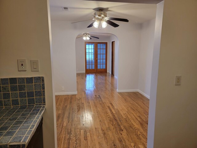 interior space with french doors, light hardwood / wood-style floors, and ceiling fan