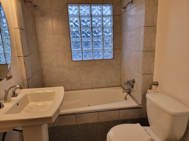 full bathroom featuring toilet, tiled shower / bath, and sink