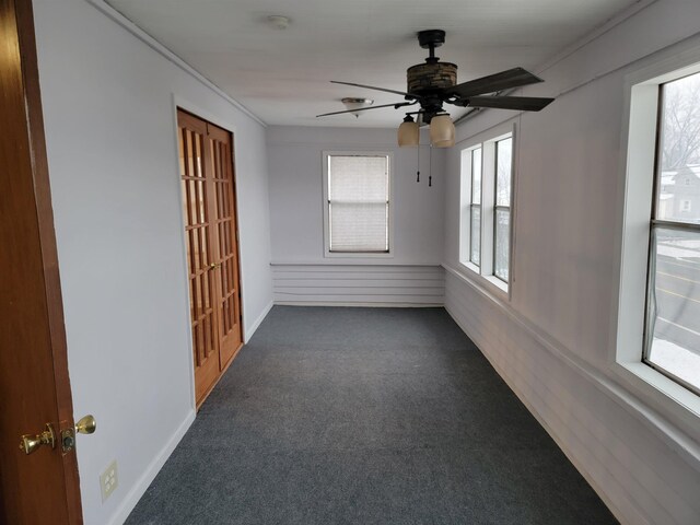 carpeted spare room with ceiling fan and ornamental molding