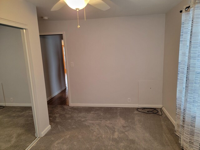 unfurnished room featuring ceiling fan and dark carpet