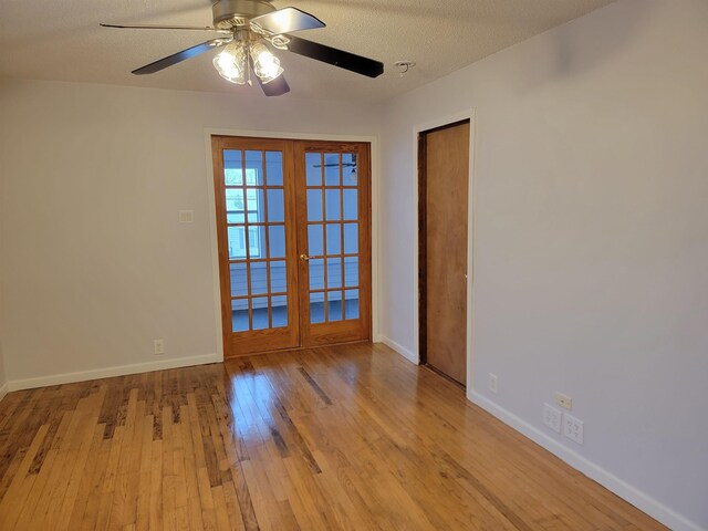 unfurnished room featuring ceiling fan, french doors, a textured ceiling, and light hardwood / wood-style flooring