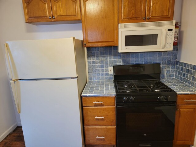 kitchen featuring white appliances and backsplash