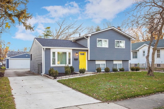 tri-level home with an outbuilding, a garage, and a front lawn