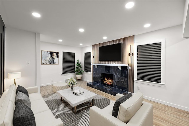 living room with light hardwood / wood-style floors and a premium fireplace