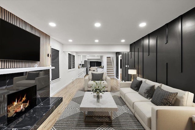 living room with a fireplace and light wood-type flooring