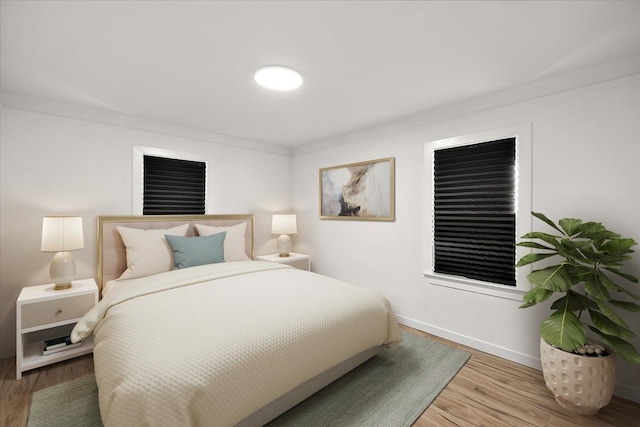 bedroom with hardwood / wood-style floors and ornamental molding