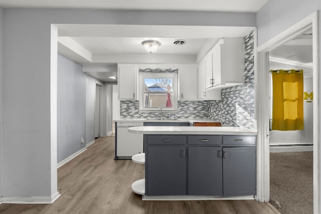 kitchen with decorative backsplash, gray cabinetry, white dishwasher, sink, and white cabinets