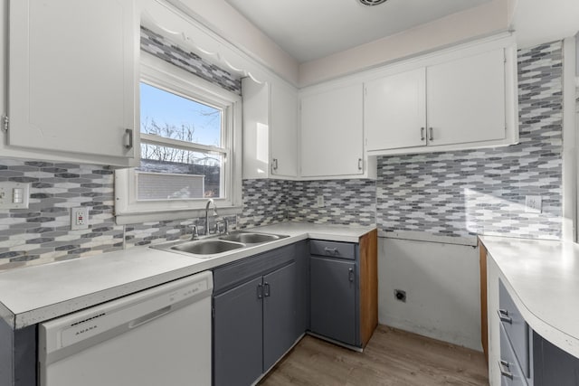 kitchen featuring hardwood / wood-style floors, white dishwasher, sink, gray cabinets, and white cabinetry