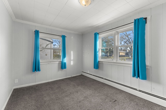 carpeted spare room featuring crown molding, plenty of natural light, and a baseboard heating unit