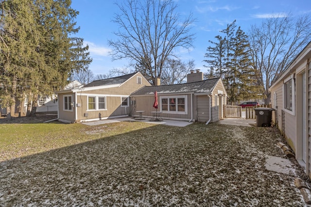 rear view of property featuring a patio and a lawn