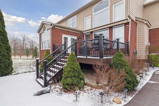 view of snowy exterior featuring a wooden deck