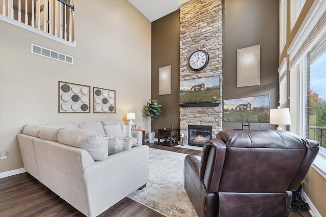 living room featuring a fireplace, high vaulted ceiling, and dark wood-type flooring