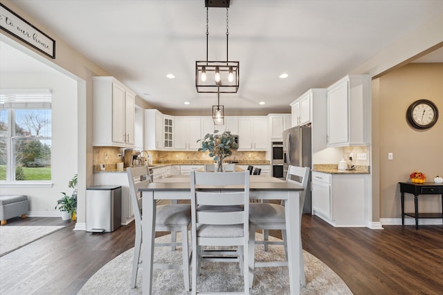 kitchen featuring white cabinets, decorative light fixtures, and dark hardwood / wood-style flooring