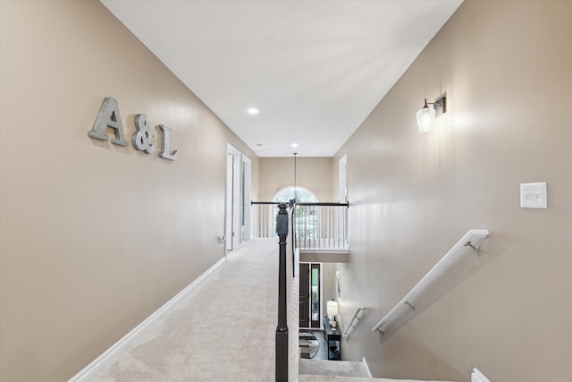 corridor with carpet floors and an inviting chandelier