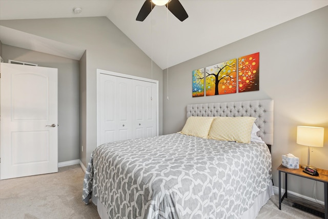 carpeted bedroom with ceiling fan, a closet, and vaulted ceiling