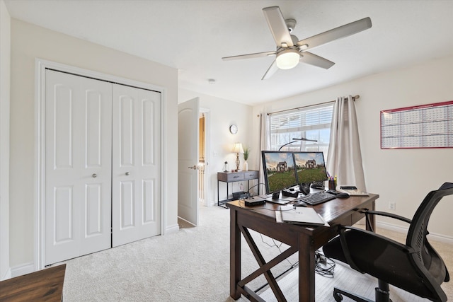 carpeted office space with ceiling fan