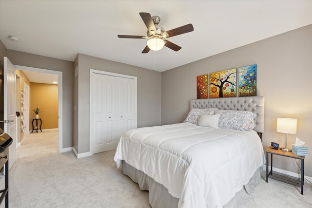 carpeted bedroom with ceiling fan and a closet