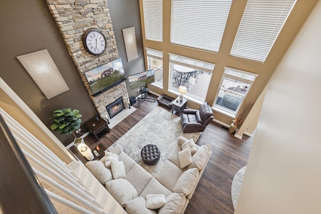 living room featuring a fireplace, a high ceiling, and dark hardwood / wood-style flooring