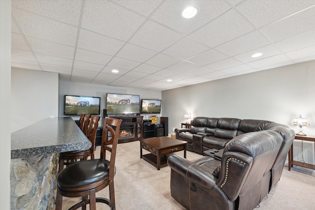 living room featuring light carpet and a paneled ceiling