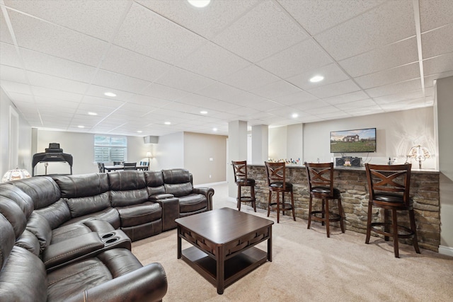 carpeted living room featuring indoor bar and a paneled ceiling