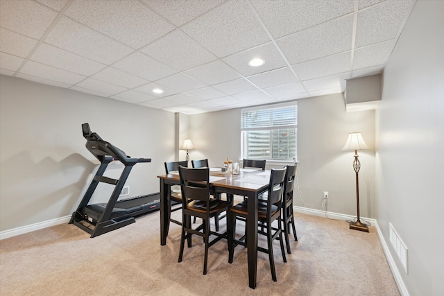 dining area with carpet and a paneled ceiling