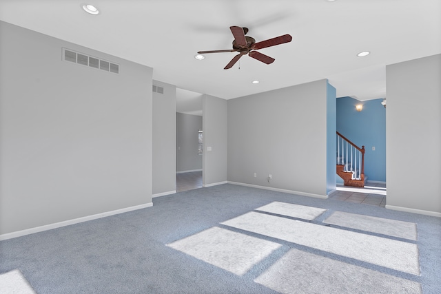 unfurnished living room featuring dark colored carpet and ceiling fan