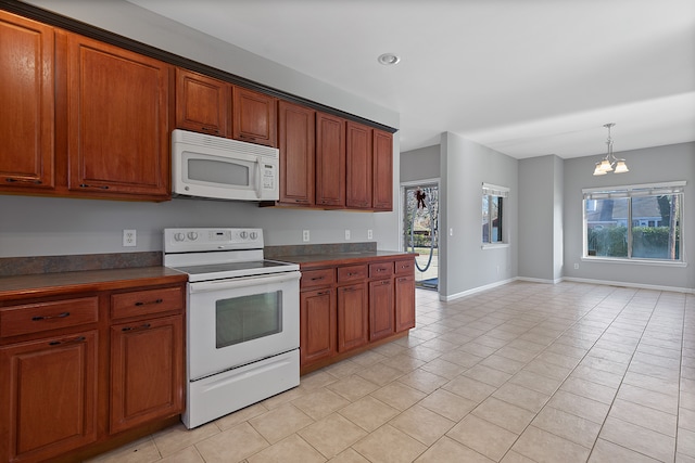 kitchen featuring pendant lighting, white appliances, a chandelier, and light tile patterned floors