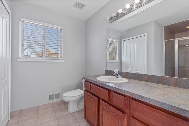 bathroom with vanity, a wealth of natural light, tile patterned floors, and toilet