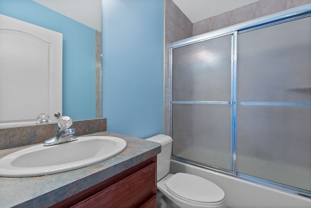 full bathroom featuring enclosed tub / shower combo, vanity, and toilet