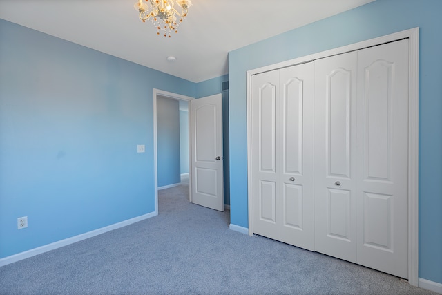 unfurnished bedroom with light carpet, a notable chandelier, and a closet