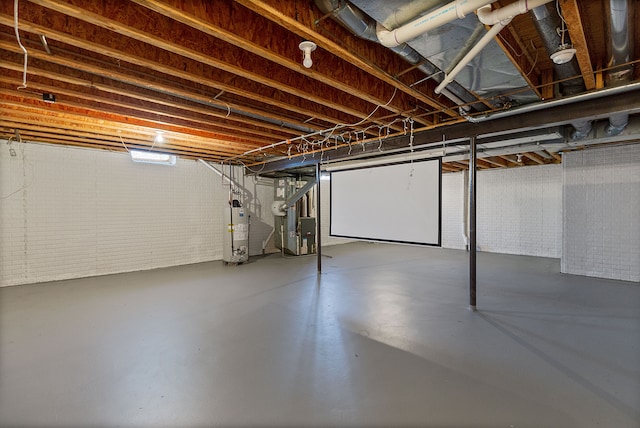 basement with brick wall, heating unit, and gas water heater