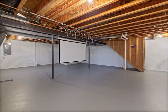 basement with electric panel and brick wall