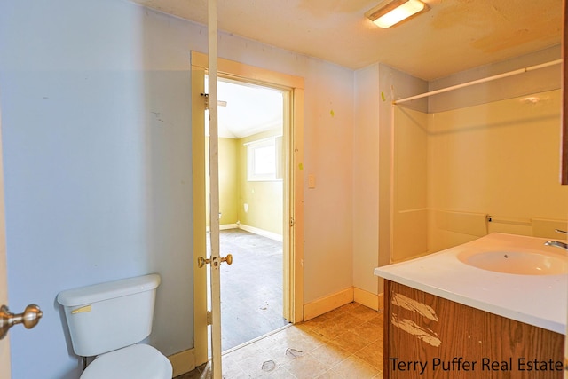 bathroom featuring a shower, vanity, and toilet